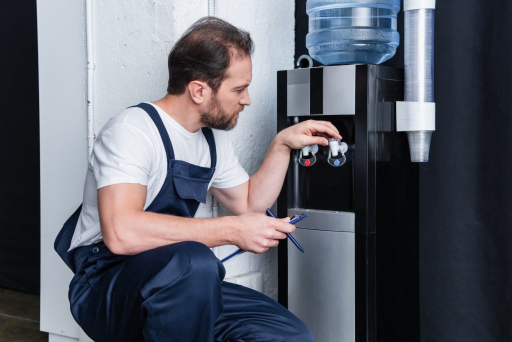 repairman with clipboard checking broken water cooler